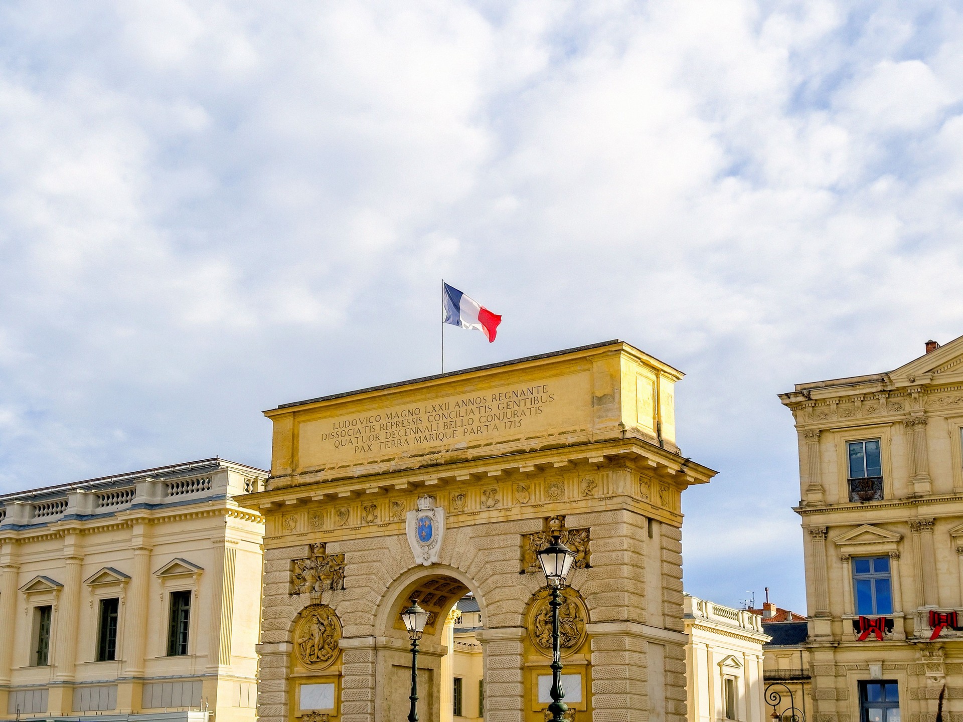 City Gate of Triumphal Arch and historic downtown buildings in Montpellier